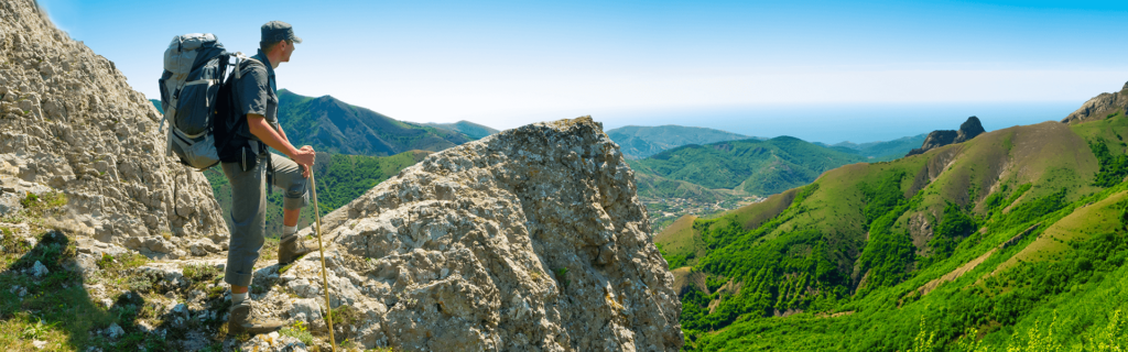 man hiking mountain after recovering from facet joint syndrome